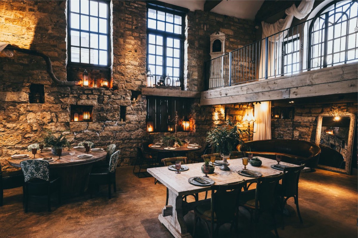The dining room at Solara Shores with stone walls and tall windows